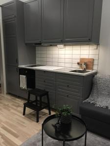 a kitchen with gray cabinets and a table and a stool at Paradise House in Motala