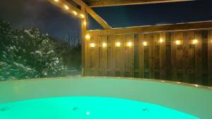 a bath tub with lights on a wooden fence at Sudecka Ostoja z Balią i Sauną in Lubawka