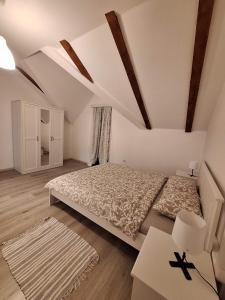 um quarto branco com uma cama, uma mesa e uma secretária em Apartman Malnar Lokve em Lokve