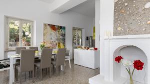 a kitchen and dining room with a table and a fireplace at VILLA MERAVIGLIA 8, Emma Villas in Nisporto