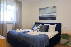 a bedroom with a blue bed with towels on it at ADA, Ferienwohnung, 6-8 Personen, Parkplatz am Haus, modern, mit Dachterrasse in Kulmbach