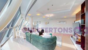 a woman sitting on a couch in a living room at Chestertons Go - Park Towers - DIFC in Dubai