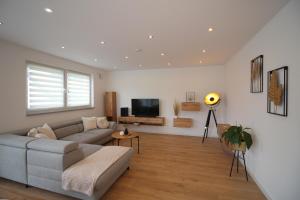 a living room with a couch and a tv at Großes Apartment mit Küche, Dusche, Badewanne, Balkon, Parkplatz vor dem Haus, ruhig gelegen, ADA4 in Kulmbach