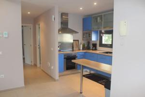 een keuken met blauwe kasten en een houten tafel bij Apartamento Benidorm a 2 minutos de playa in Benidorm