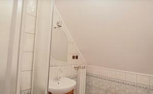 a white bathroom with a sink and a shower at Kolędówka Rest in Zawoja