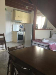 eine Küche und ein Esszimmer mit einem Tisch im Zimmer in der Unterkunft Kostas--Sarantis--2 in Lakíthra