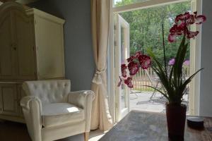 a living room with a chair and a window at B&B De BonAparte in Heemskerk