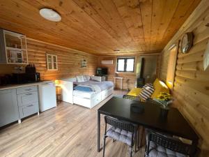 a living room with a bed and a kitchen at Pipi Vityilló in Füzérradvány