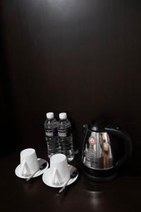 Kirei Inn في ناغويا: طاولة مع زجاجتين من المياه وآلة صنع القهوة