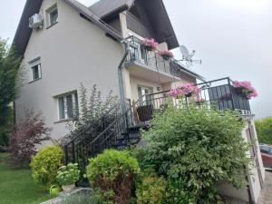 a white house with flowers on the balconies at Słoneczne Wzgórze in Szczawnica