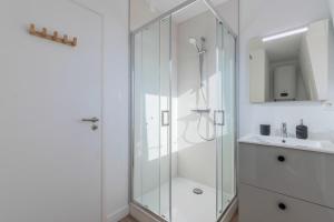 a white bathroom with a shower and a sink at 1 bedroom duplex apartment, with parking in Tourcoing
