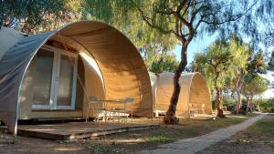 kilka namiotów zaparkowanych obok drzewa w obiekcie Camping Bella Vista w mieście Ceriale