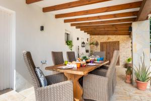 a dining room with a wooden table and chairs at Villa Can Truyet in Santa Eularia des Riu