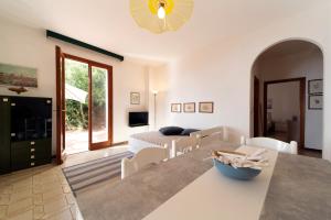 cocina y sala de estar con mesa y sillas en Appartamenti Villa Innamorata, en Capoliveri
