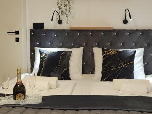 a bed with a black headboard and two wine glasses at Adriatic SPA Apartment in Selce