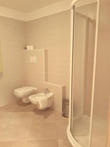 bagno bianco con servizi igienici e doccia di Appartamento Alba a Folgaria