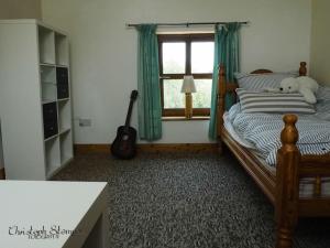 a bedroom with a bed with a teddy bear on it at Stonechat Cottage - Portmagee in Portmagee