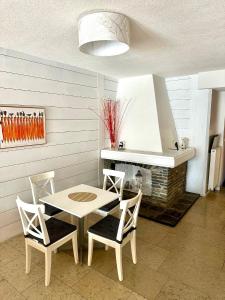 eine Küche mit einem Tisch, 2 Stühlen und einem Herd in der Unterkunft RELAX Seefeld Apartman in Seefeld in Tirol