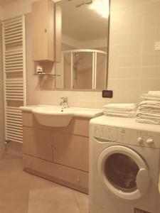 y baño con lavadora y lavamanos. en Appartamento Alba, en Folgaria