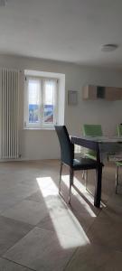 a dining room with a table and a green chair at Appartamento Alba in Folgaria +3 photos