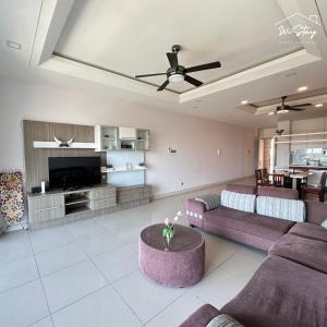a living room with purple couches and a tv at WiStay - NEW COZY 3 BEDROOM APARTMENT AT IMAGO The LOFT B "Seaview and Golf course view" in Kota Kinabalu
