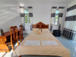 een slaapkamer met een bed en een tafel en ramen bij Vườn Quốc Gia U Minh Hạ in Xóm Mũi