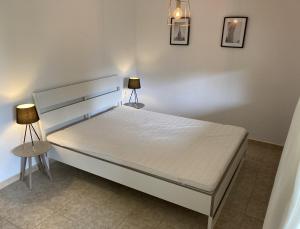 ein Schlafzimmer mit einem Bett mit zwei Lampen in der Unterkunft Architect Villa with Infinity Pool near Beach&Golf in Santa Cristina d'Aro