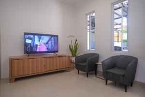 a living room with two chairs and a flat screen tv at RedDoorz near Stasiun Solo Balapan 3 in Bonorejo