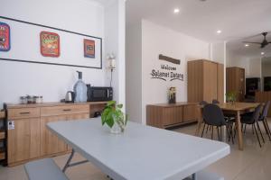 a dining room with a white table and chairs at RedDoorz near Stasiun Solo Balapan 3 in Bonorejo