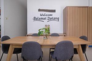 a conference room with a wooden table and chairs at RedDoorz near Stasiun Solo Balapan 3 in Bonorejo