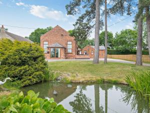 a brick house with a pond in front of it at 4 Bed in Balderton 94158 in Balderton