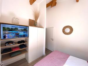 a bedroom with a flat screen tv and a bed at Appart Cala Rossa - T2 Porto-Vecchio in Lecci