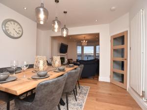 a dining room with a table and chairs and a clock at 4 Bed in Aberdovey 94232 in Aberdyfi