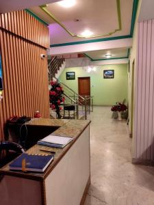 an office with a desk and a lobby with a staircase at Hotel Foothills , Srinagar in Srinagar