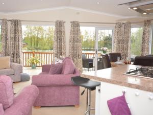 a kitchen and living room with purple furniture and windows at 2 Bed in Tattershall Lakes 50360 in Tattershall