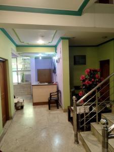 Zimmer mit grünen Wänden und einem Tisch mit Blumen in der Unterkunft Hotel Foothills , Srinagar in Srinagar