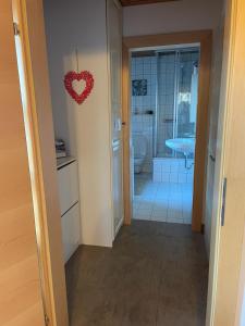 a bathroom with a heart hanging on the wall at Ferienwohnung Kendlbacher in Bischofshofen