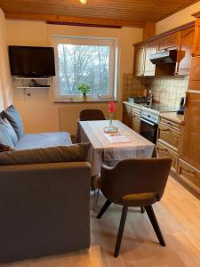 a kitchen and living room with a table and a couch at Ferienwohnung Kendlbacher in Bischofshofen