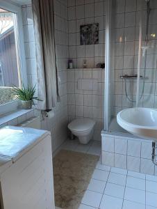 Baño blanco con aseo y lavamanos en Ferienwohnung Kendlbacher en Bischofshofen