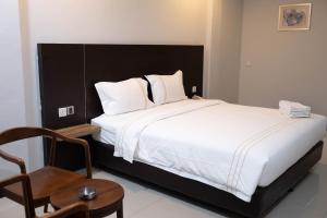 um quarto com uma cama grande e uma cadeira em Kirei Inn em Nagoya