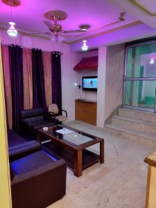 sala de estar con sofá, mesa y TV en Hotel Foothills , Srinagar, en Srinagar
