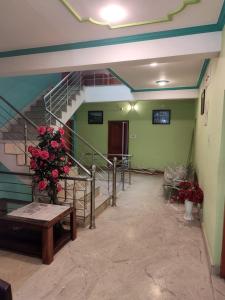 a hallway with stairs and a vase of flowers at Hotel Foothills , Srinagar in Srinagar
