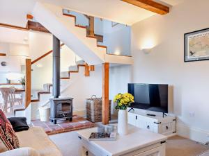 a living room with a staircase and a fireplace at 2 Bed in Cirencester 93878 in Coates