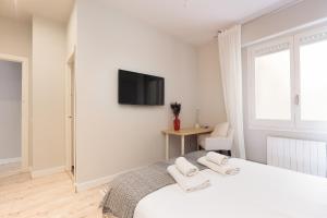 1 dormitorio blanco con 1 cama y TV en la pared en LetsGo Diagonal Avenue Apartment en Barcelona
