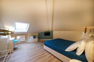 a bedroom with a blue bed and a skylight at La Mansardina di Rapallo in Rapallo