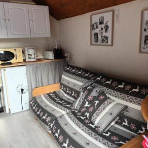 uma cama num pequeno quarto com um cobertor de comboio em Appartement avec vue em Savines-le-Lac