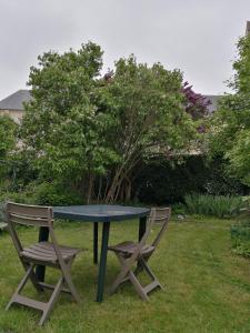 a table and two chairs sitting next to a tree at maison entre terre et mer in Bonnebosq