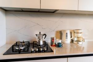 a kitchen counter with a stove top with coffee makers at Incanto a Spello: Raffinato Appartamento per Due in Spello