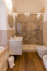 uma casa de banho com um chuveiro, um lavatório e um WC. em Incanto a Spello: Raffinato Appartamento per Due em Spello