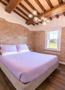 a bedroom with a large white bed with a window at Incanto a Spello: Raffinato Appartamento per Due in Spello